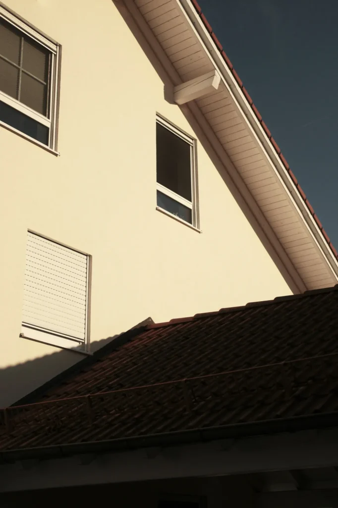 Giebel eines verputzten Wohnhauses im Abendlicht